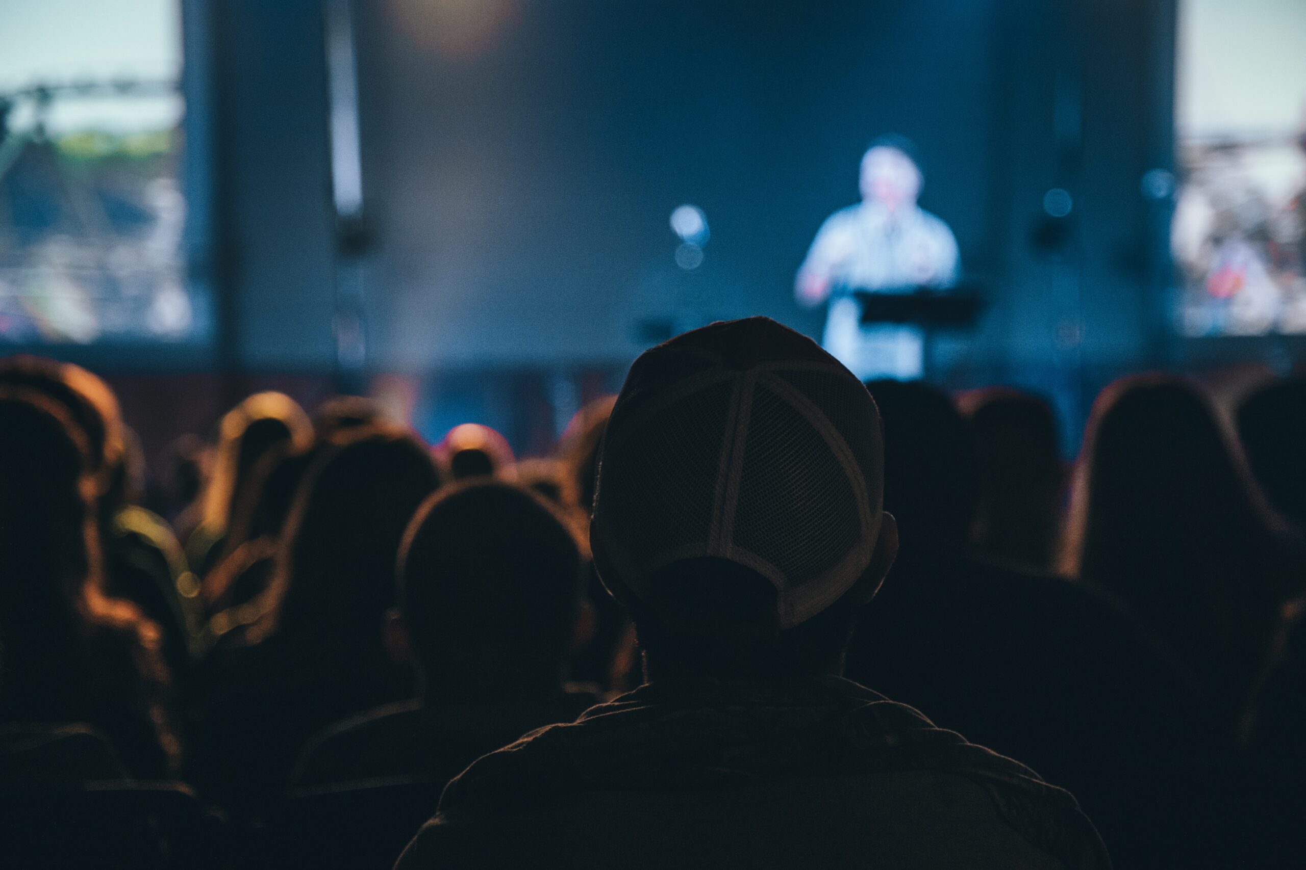 Photo of a person onstage speaking to a crowd